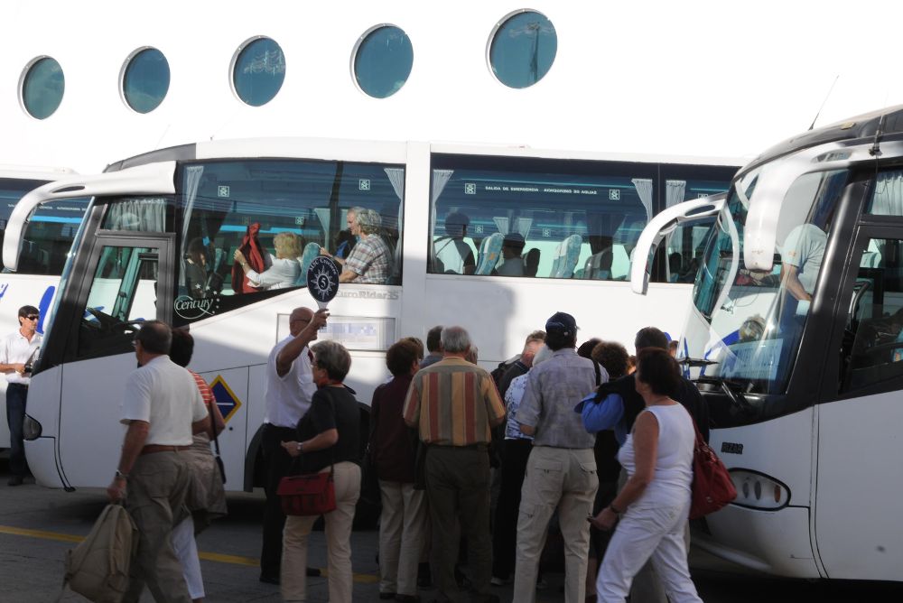 Turistas de un crucero suben a las guaguas para realizar sus excursiones.