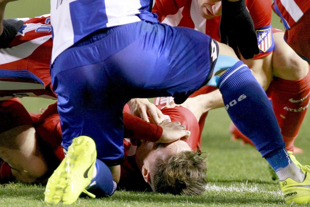 Los jugadores del Atlético de Madrid y del Deportivo de la Coruña asisten Fernando Torres tras sufrir un golpe y quedar incosciente.