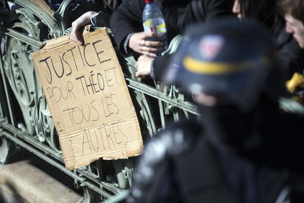 Estudiantes muestran una pancarta en la que se puede leer "Justicia por Theo y por otros" mientras son desalojados de la Plaza de la Nación tras una breve protesta contra la brutalidad policial en París (Francia) el 2 de marzo de 2017.