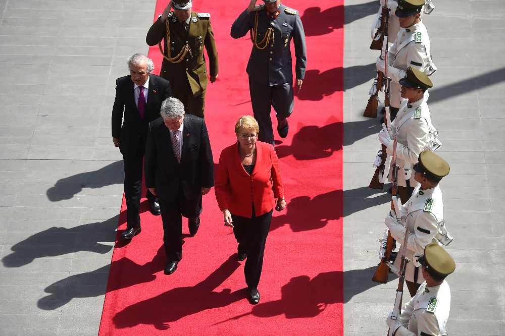 La presidenta de Chile, Michelle Bachelet (c), caminando junto al presidente de la Corte Suprema Hugo Dolmestch (2-i) y el ministro de la Corte Suprema Miltón Juica (i).