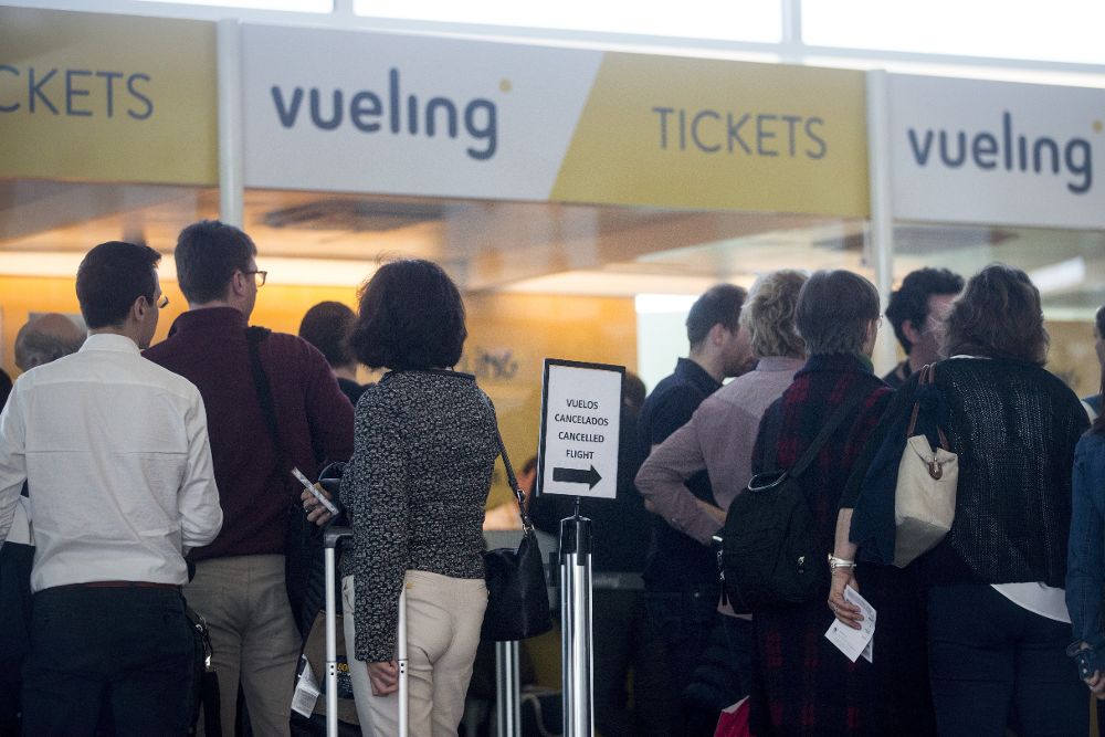 Varios viajeros en los mostradores de la aerolínea Vueling.
