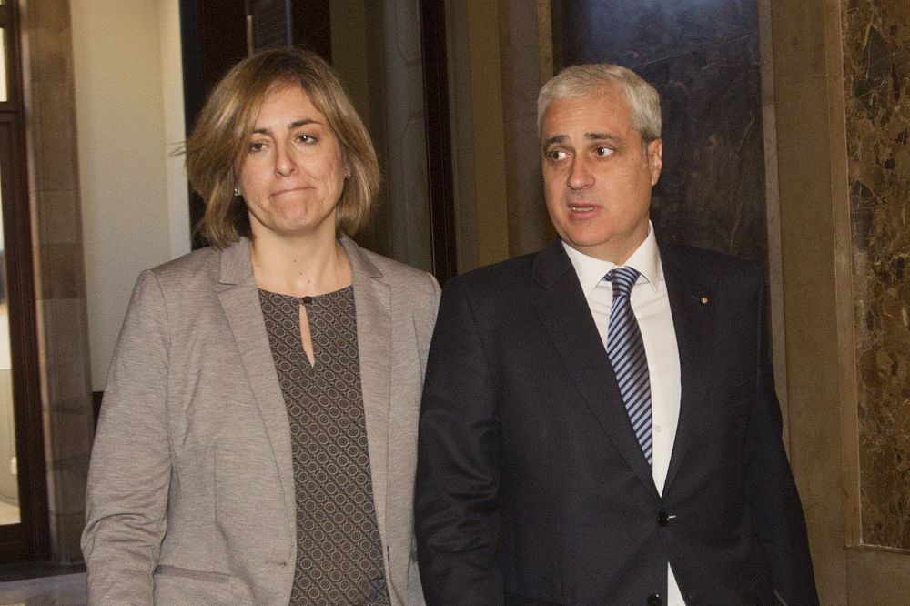 El exconseller y diputado del PDeCAT, Germà Gordó, junto a una colaboradora hoy en los pasillos del Parlament de Cataluña.