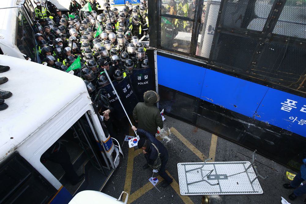 Simpatizantes de la presidenta Park Geun-hye se enfrentan a la policía tras la ratificación de la destitución de la mandataria a manos del Tibunal Consitucional en Seúl (Corea del Sur) hoy, 10 de marzo de 2017.