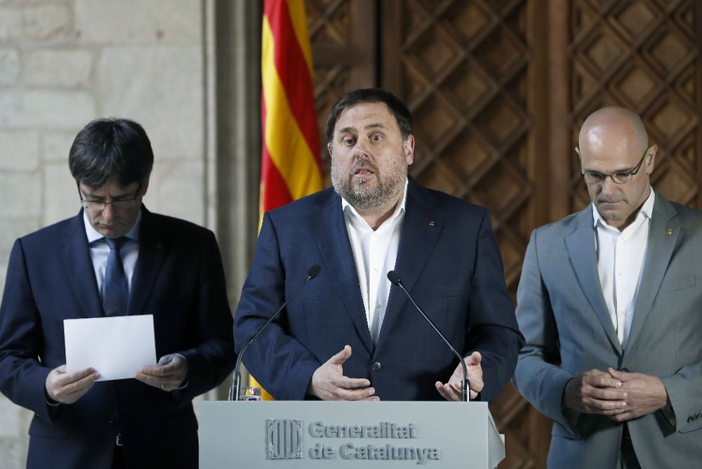 El vicepresidente del Govern, Oriol Junqueras (c), acompañado del presidente de la Generalitat, Carles Puigdemont (i), y el conseller de Exteriores, Raül Romeva.
