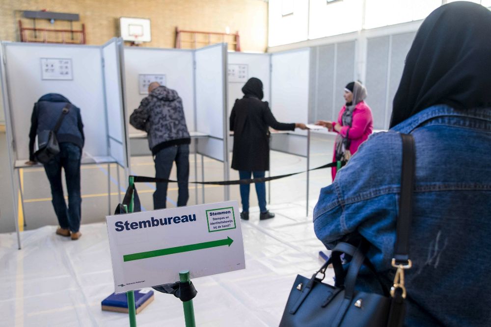 Ciudadanos depositan sus votos en unas cabinas durante las elecciones parlamentarias, en Rotterdam (Holanda), hoy, 15 de marzo de 2017. 