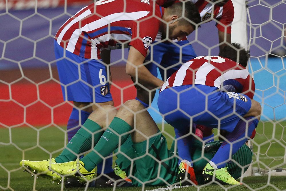 Los jugadores del Atlético atienden a su compañero el portero Oblak tras recibir este un golpe.