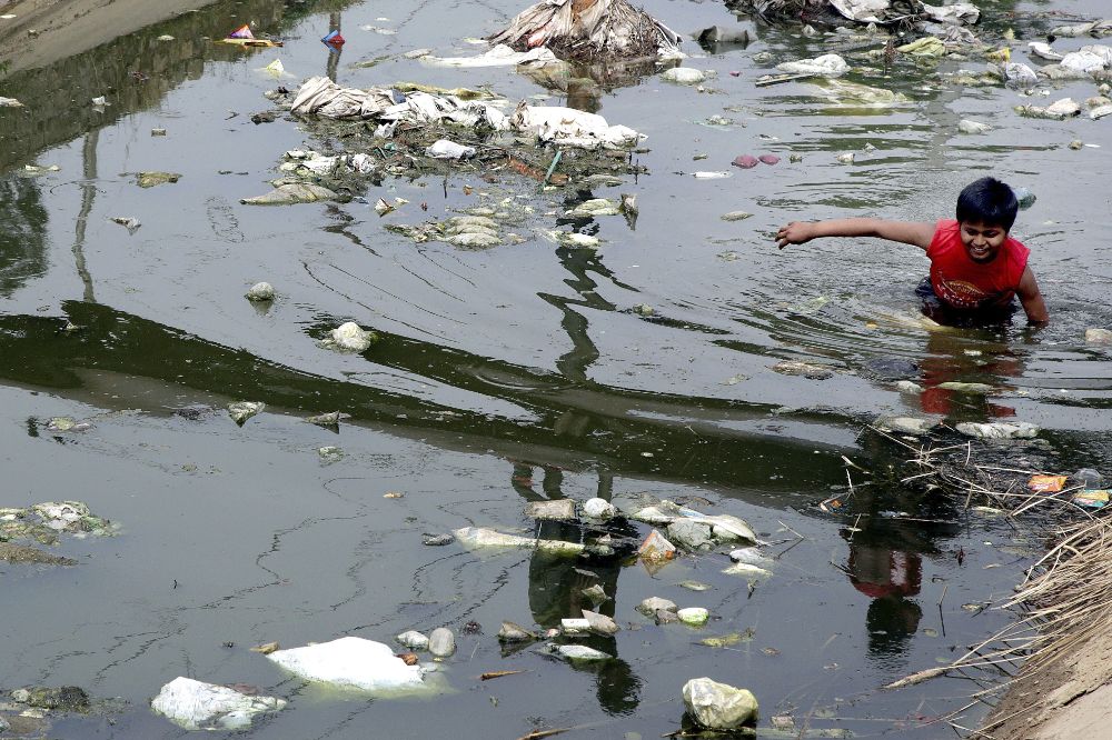 Un niño en un canal de riego contaminado en Jammu, en la Cachemira india.