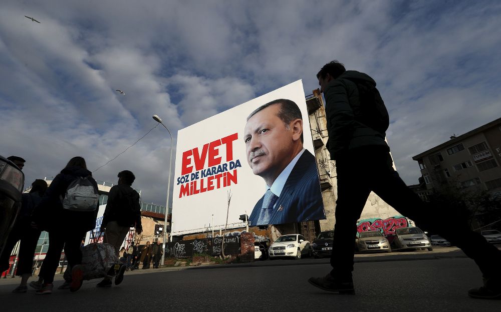Varias personas caminan ante un cartel con la imagen del presidente turco, Recep Tayyip Erdogan, en Estambul.