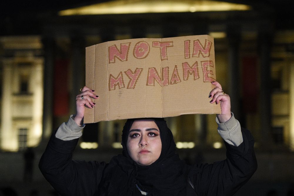 Una mujer sostiene una pancarta durante una vigilia en la céntrica plaza de Trafalgar, donde los londinenses rindieron ayer tributo a las víctimas del atentado frente al Parlamento.