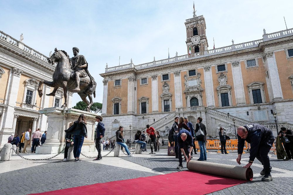 Trabajadores colocan la alfrombra roja a las puertas del Palacio Campidoglio, Ayuntamiento de Roma, durante los preparativos para la conmemoración del sesenta aniversario del Tratado de Roma.