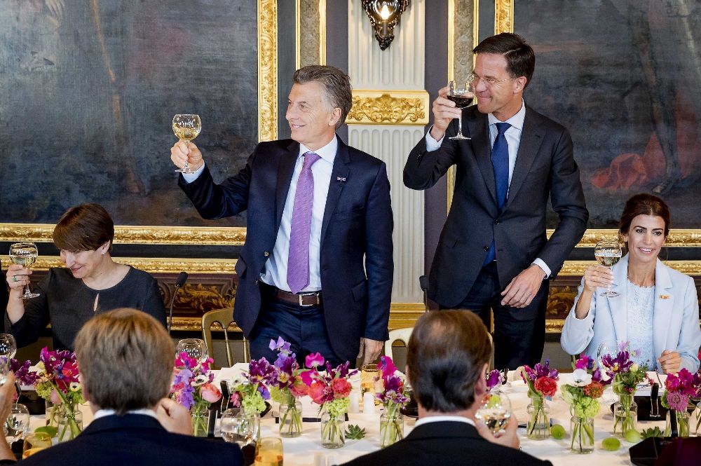 El presidente argentino, Mauricio Macri (2i), y su mujer, Juliana Awada (d), asisten a una comida con el primer ministro holandés, Mark Rutte (2d); la ministra de Comercio Exterior, Lilianne Ploumen (i); y el rey Guillermo-Alejandro de Holanda (i, de espaldas) durante su visita en la Haya (Holanda) hoy, 28 de marzo de 2017.