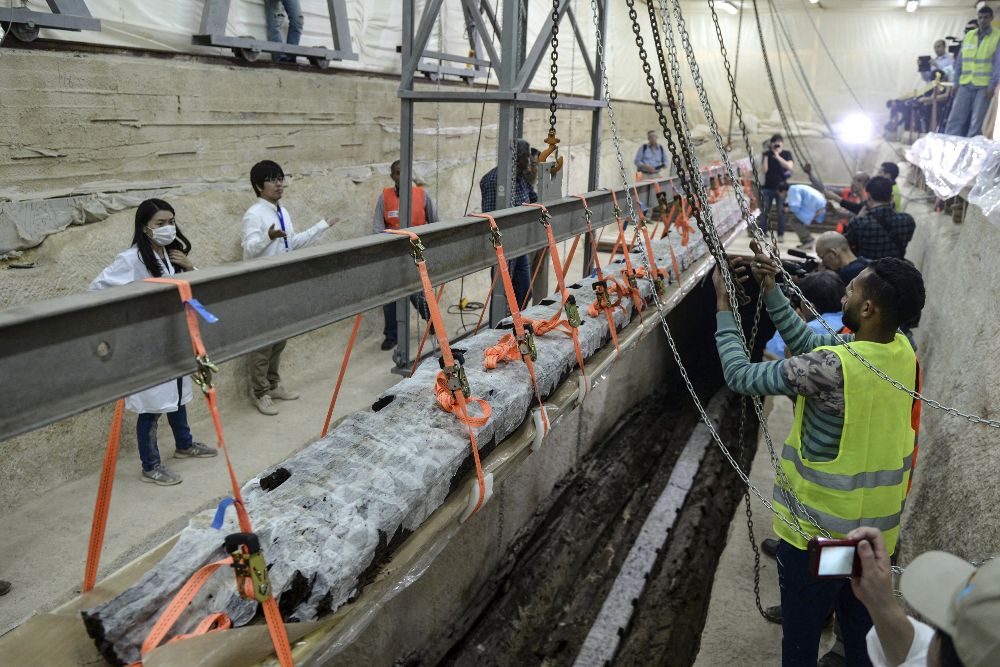 Arquéologos levantan una pieza de madera de 26 metros de la segunda barca funeraria de Keops antes de su restauración en Guiza (Egipto) hoy, 29 de marzo de 2017.