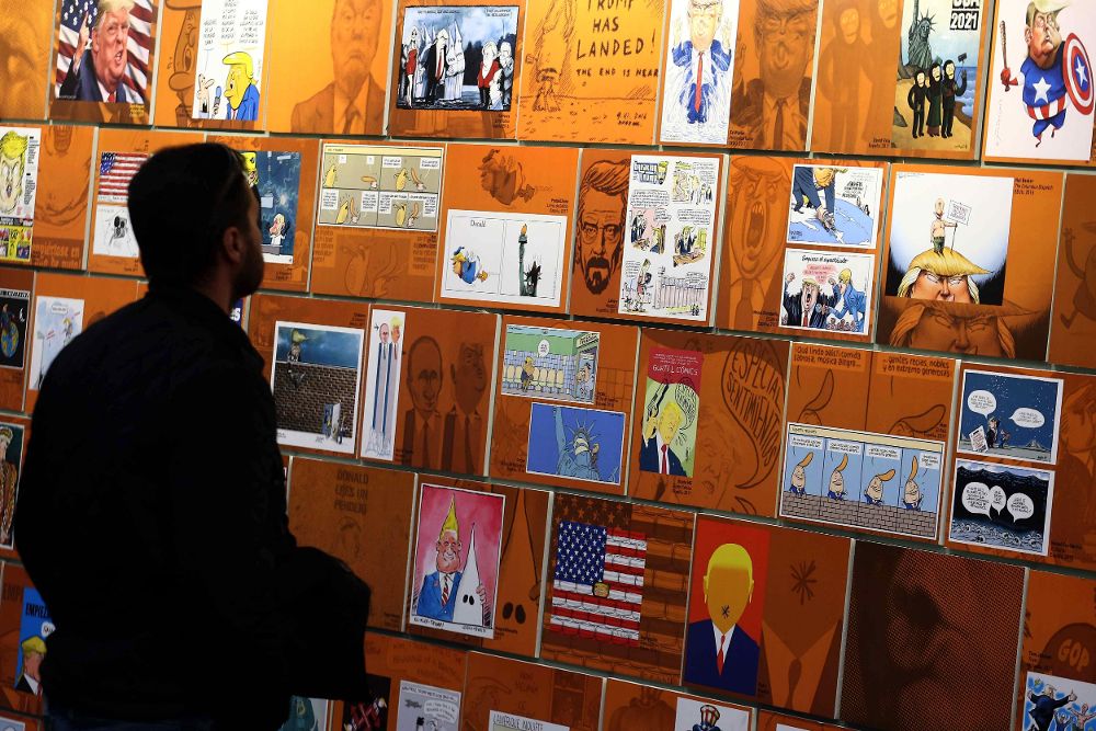 Un visitante observa varios "retratos" de Donald Trump en el Salón del Cómic de Barcelona.