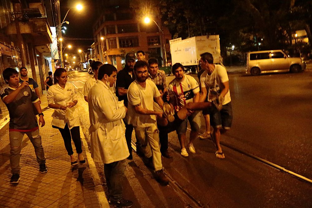 Estudiantes atienden a los numerosos heridos tras los disturbios originados durante las protestas contra la reelección presidencial en Paraguay. 
