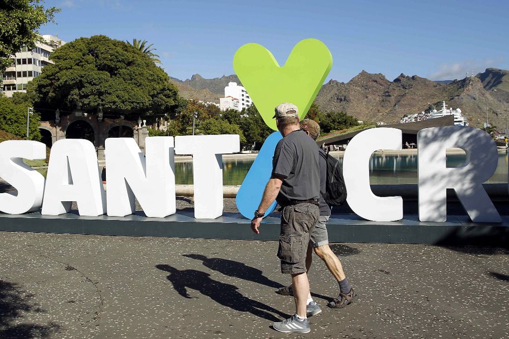 Dos turistas pasan frente al nuevo logo que pretende ser la imagen de la capital.