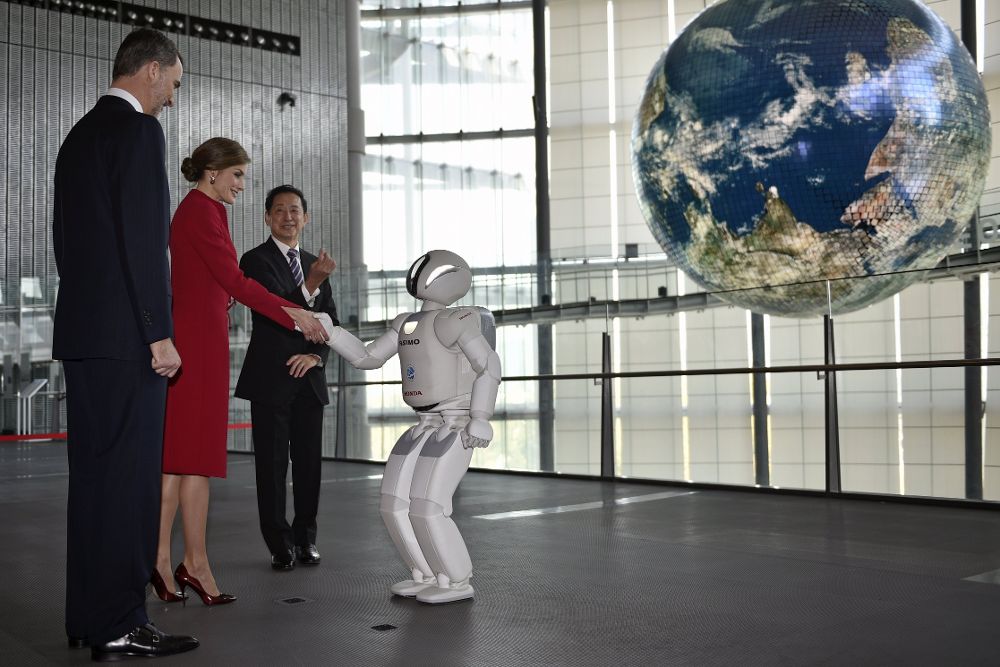 El rey Felipe VI (i) y la a reina Letizia (2i) saludan al robot Asimo de Honda (d) durante su visita al Museo Nacional de la Ciencia Emergente y la Innovación (Miraikan) en Tokio (Japón) hoy, 5 de abril de 2017.