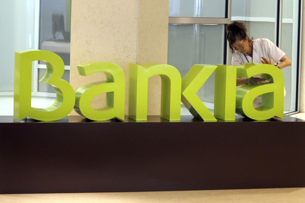 Una operaria limpia el logo de Bankia, entidad que interpuso el recurso ante el Supremo, que le ha dado la razón.
