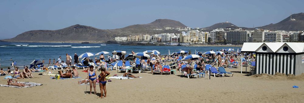 Turistas y vecinos de Las Palmas de Gran Canaria disfrutan de un día de sol en la playa de Las Canteras.