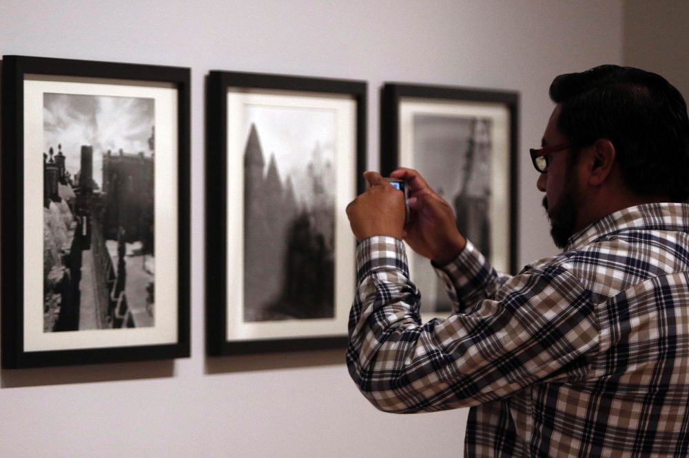 Un hombre toma fotografía en la exposición "El fotógrafo Juan Rulfo".