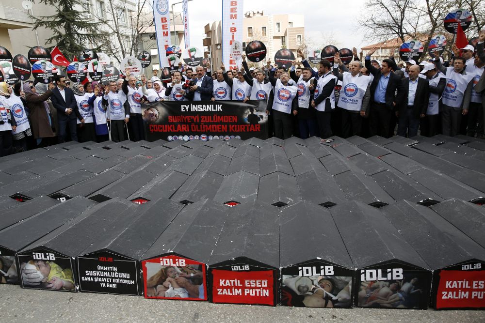 Manifestantes gritan consignas contra Rusia junto a ataúdes simbólicos en los que se puede leer "Asesino Asad, asesino Putin" en solidaridad con las víctimas del supuesto ataque químico que sufrió la localidad siria de Jan Shijún en una protesta frente a la Embajada de Rusia en Ankara (Turquía) hoy, 7 de abril de 2017.