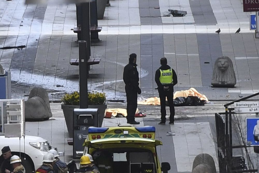 La policía custodia el cuerpo de una de las víctimas del atentado en el centro de Estocolmo, Suecia hoy 7 de abril de 2017 donde un camión arrolló a los viandantes en una zona peatonal de la ciudad. Al menos tres personas han muerto al atropellar un camión a varios viandantes en el centro de Estocolmo en lo que las autoridades consideran un atentado terrorista, confirmó el primer ministro sueco, Stefan Löfven.
