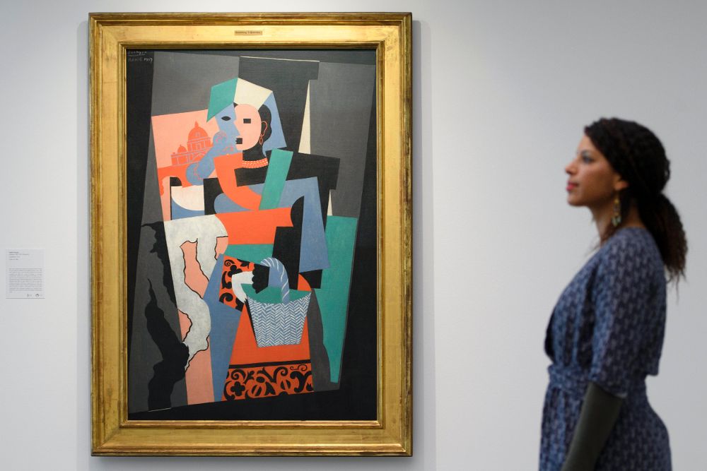 Una mujer pasa delante del cuadro "L'Italienne" del artista español Pablo Ruiz Picasso.