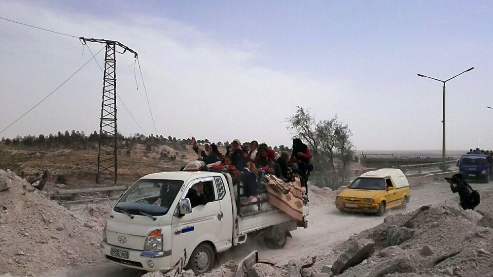 Un grupo de personas huye de los combates entre fuerzas de coalición y miembros de ISIS, en Al Raqa. 