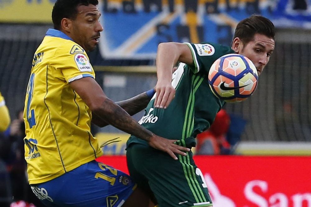 El defensa brasileño de la UD Las Palmas Michel Macedo (i) lucha con Álex Alegría, delantero del Real Betis.