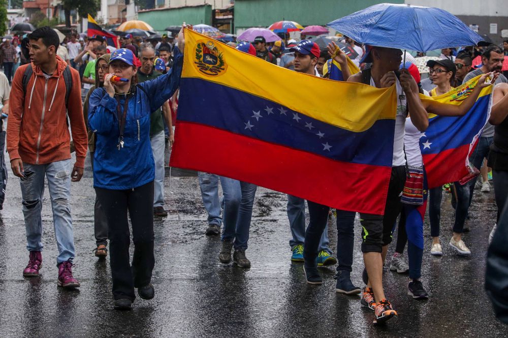Un grupo de personas participa en una manifestación en contra del gobierno venezolano.