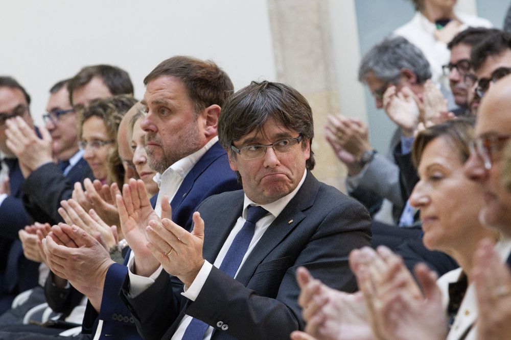 El presidente catalán, Carles Puigdemont (c), y el vicepresidente Oriol Junqueras (i), participan en un acto de apoyo a Carme Forcadell (d) y los miembros de la Mesa contra quienes se presentó una querella por desobediencia al TC a raíz del proceso soberanista.