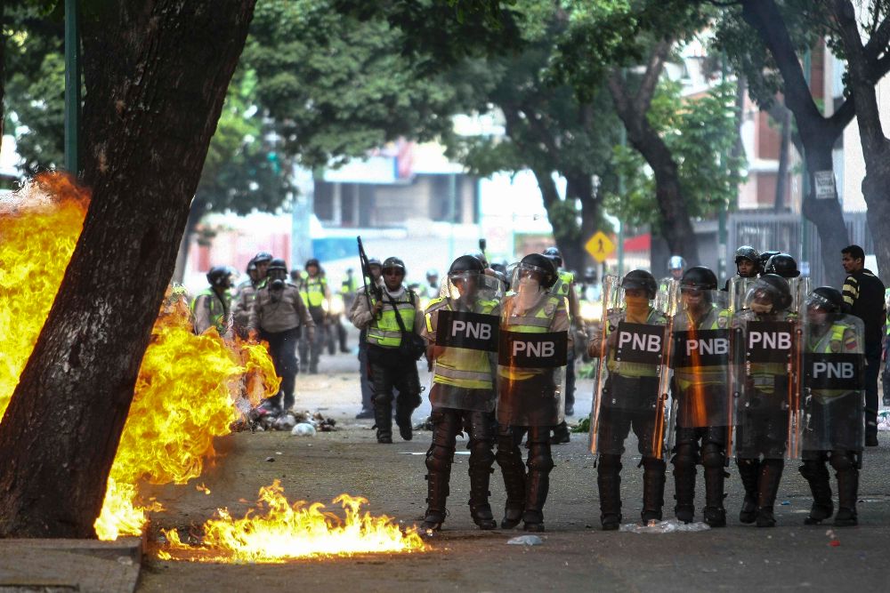 Agentes de la Policía Nacional Bolivariana (PNB) bloquean el paso de una marcha opositora.