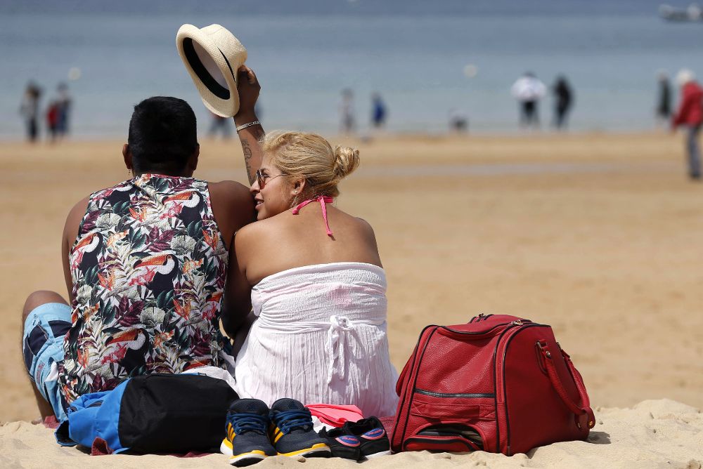 Turistas disfrutan en la playa de la Concha de San Sebastián de los cielos despejados y temperaturas primaverales. 