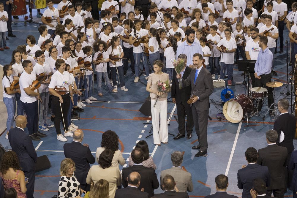 Los reyes Felipe y Letizia tras recibir obsequios de los niños que participan en el proyecto socioeducativo 'Barrios Orquestados', que hoy les ofrecieron un concierto, durante el primer día de la visita que realizan a Canarias.