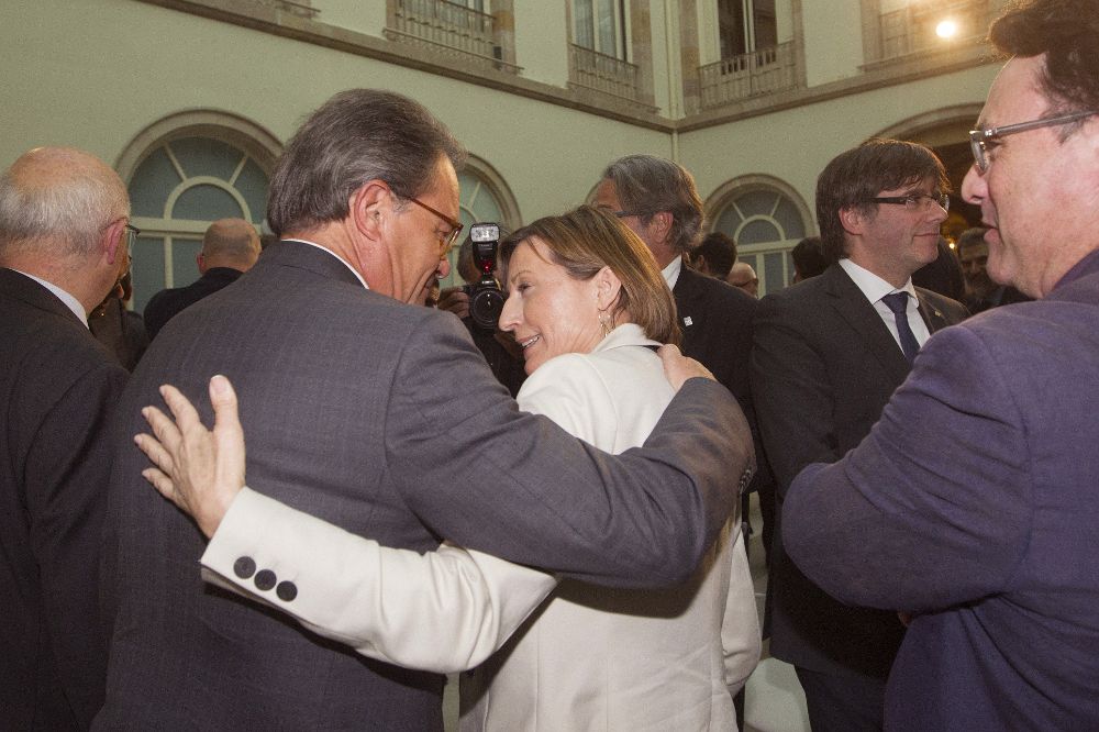La presidenta del Parlament catalán, Carme Forcadell (c), se despide del expresidente catalán Artur Mas (2i), ante la mirada de Joan Josep Nuet (d).