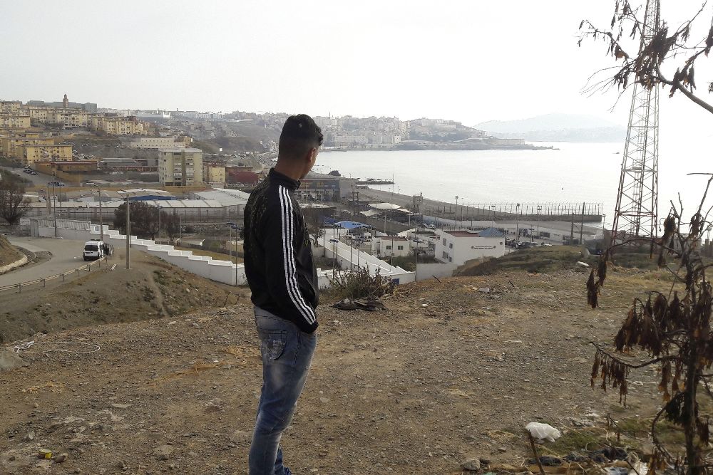 Un hombre observa el paso fronterizo de Ceuta.