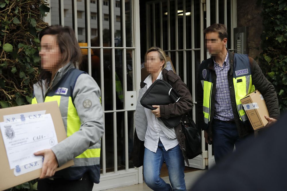 Dos policías sacan cajas del domicilio del expresidente de la Generalitat Jordi Pujol, en Barcelona, al acabar uno de los registros realizados hoy.