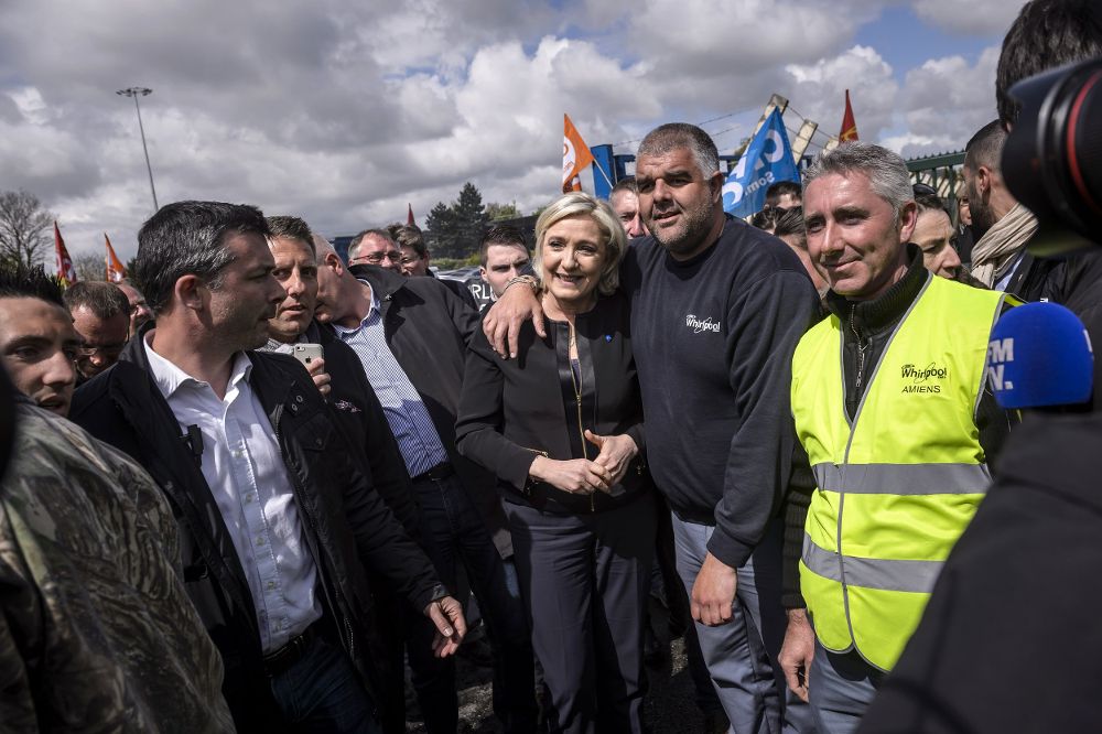 La candidata ultraderechista a las elecciones presidenciales francesas, Marine Le Pen (c), posa junto a empleados de la firma estadounidense Whirlpool frente a la fábrica de la compañía Amiens (Francia) ayer, 26 de abril de 2017.