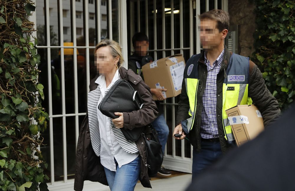Dos policías sacan cajas del domicilio del expresidente de la Generalitat Jordi Pujol, y su esposa, Marta Ferrusola, en Barcelona.
