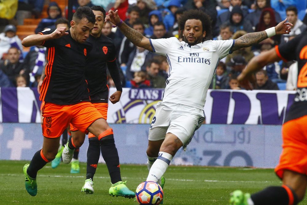 El defensa brasileño del Real Madrid Marcelo Vieira (d) disputa un balón con el jugador del Valencia Munir El Haddadi (i) durante el partido correspondiente a la trigésimo quinta jornada de LaLiga Santander disputado hoy en el estadio Santiago Bernabéu.