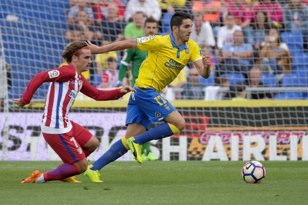 El delantero francés del Atlético de Madrid Antoine Griezmann (i) disputa un balón con el defensa de Las Palmas Pedro Bigas (d).