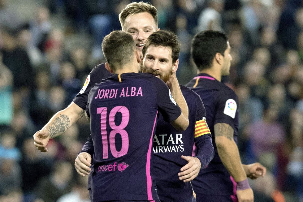Los jugadores del FC Barcelona, Jordi Alba, Leo Messi e Ivan Rakitic celebran el segundo gol del equipo frente al RCD Espanyol, durante el partido de la trigésima quinta jornada de la Liga de Primera División que se juega hoy en el RCDE Stadium.