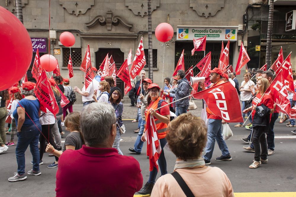 Dos personas observan el paso de la manifestación convocada por los sindicatos CCOO, UGT, Cobas, FSOC, CUO, USO Canarias y CSIF en Santa Cruz de Tenerife con motivo del primero de Mayo y bajo el lema "Por empleos y salarios dignos". "