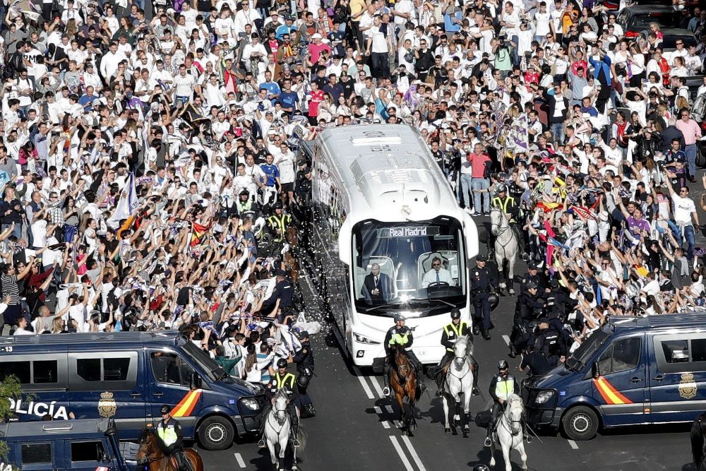 Aficionados del Real Madrid reciben el autocar que traslada a los jugadores al estadio Santiago Bernabéu de Madrid, antes del partido de ida de semifinales de la Liga de Campeones que el Real Madrid y el Atlético de Madrid disputarán hoy.