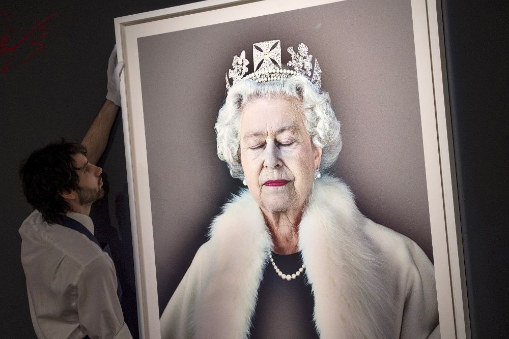 Un trabajador coloca el retrato de la reina Isabel II de Inglaterra titulado "Levedad del ser", obra del fotógrafo británico Chris Levine.