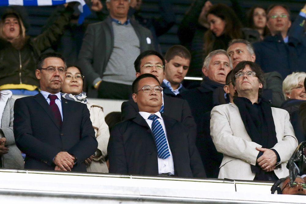 El presidente de la Generalitat de Cataluña, Carles Puigdemont (d), El presidente del RCD Espanyol Chen Yansheng (c) y el presidente del FC Barcelona Josep Maria Bartomeu (i) durante el partido en el estadio de Cornellà-El Prat entre el RCD Espanyol y FC Barcelona.