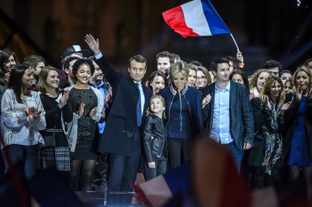 Emmanuel Macron (i) celebra con su esposa y algunos seguidores su virtual victoria desde el Carrousel del Louvre, en París.