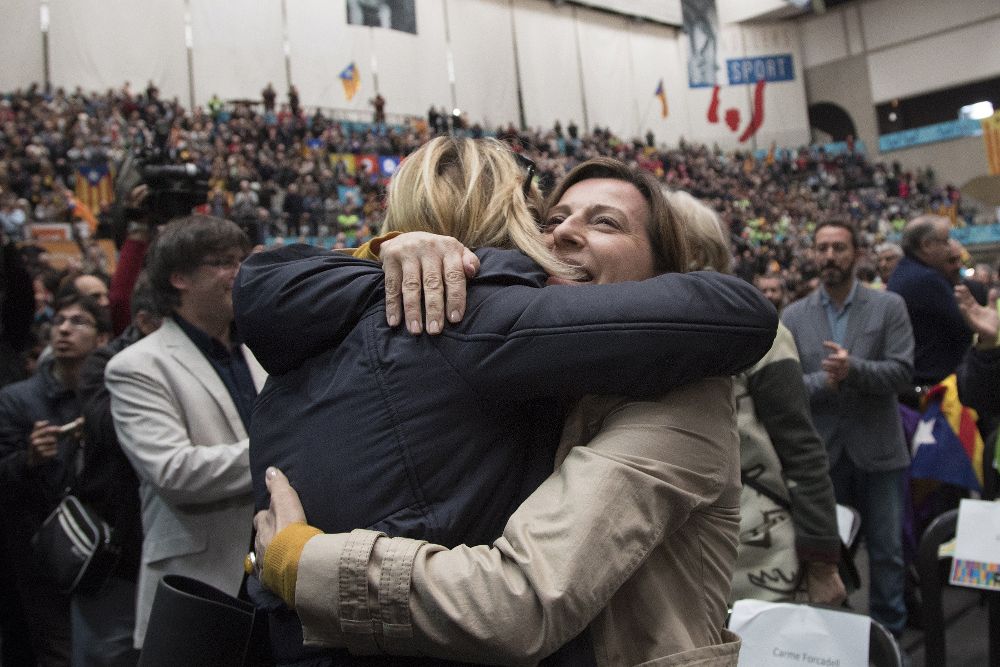 La presidenta del Parlament, Carme Forcadell (d), abraza a Joana Ortega, consellera inhabilitada por la consulta del 9N de 2014.