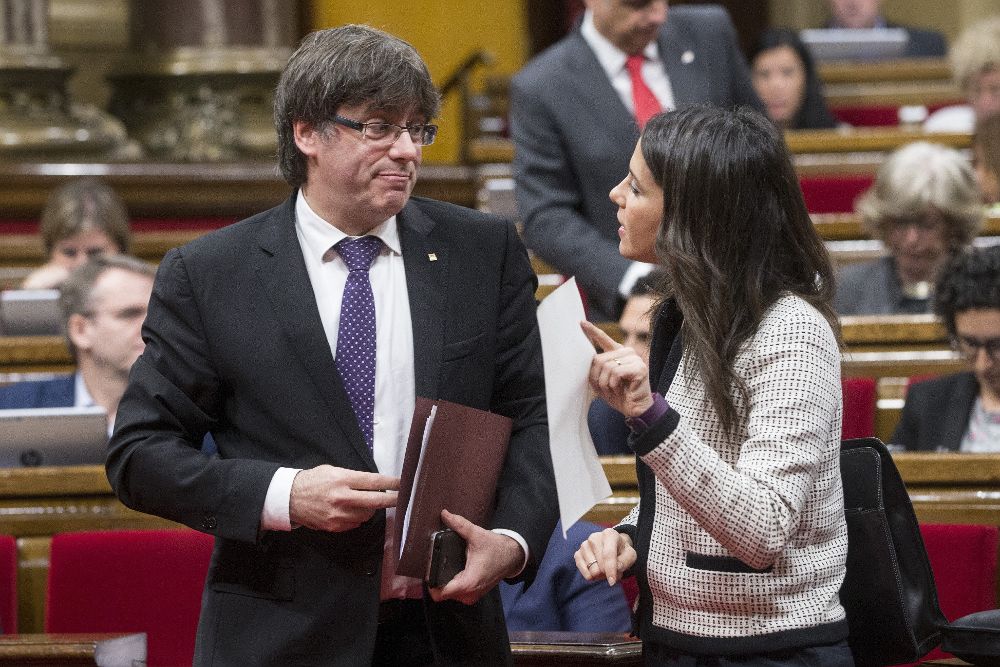 El presidente de la Generalitat de Cataluña, Carles Puigdemont, habla con la líder de Ciudadanos, Inés Arrimadas, en el Parlament.