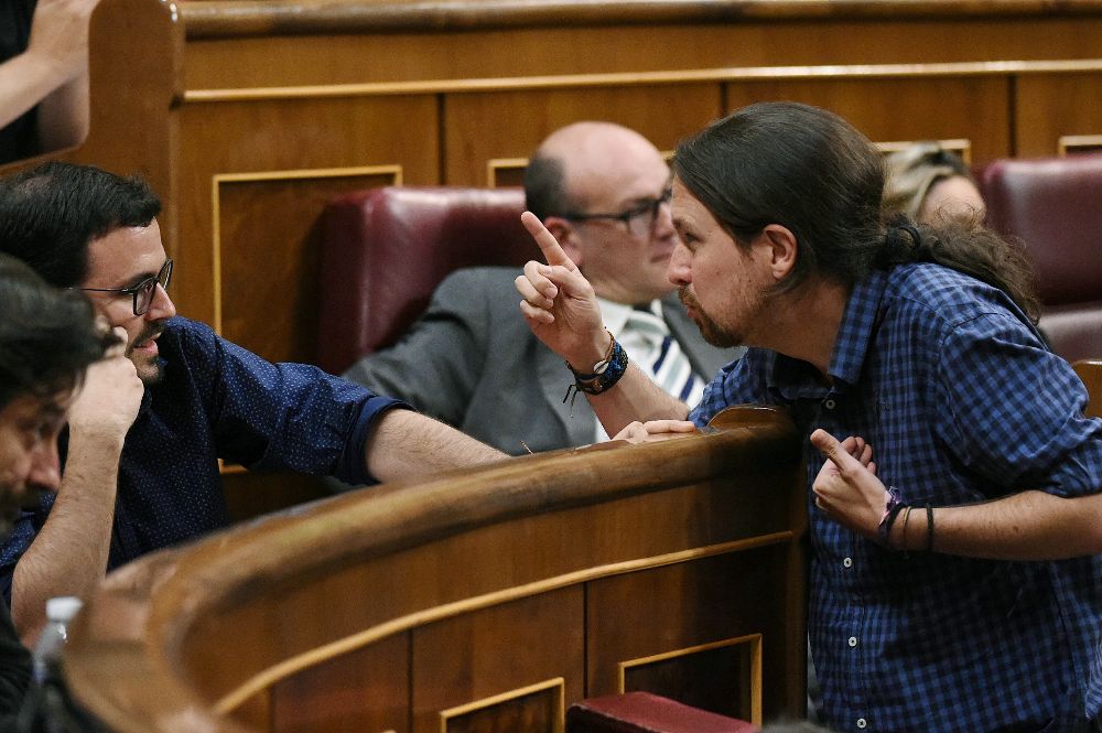 El líder de Podemos, Pablo Iglesias (d), conversa con el coordinador federal de IU, Alberto Garzón (2i), durante el pleno del Congreso, esta tarde en Madrid.
