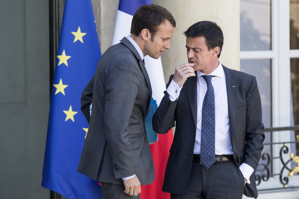 Foto de archivo del entonces primer ministro galo, Manuel Valls (dcha), mientras conversa con el que fuera ministro de Economía, Emmanuel Macron.